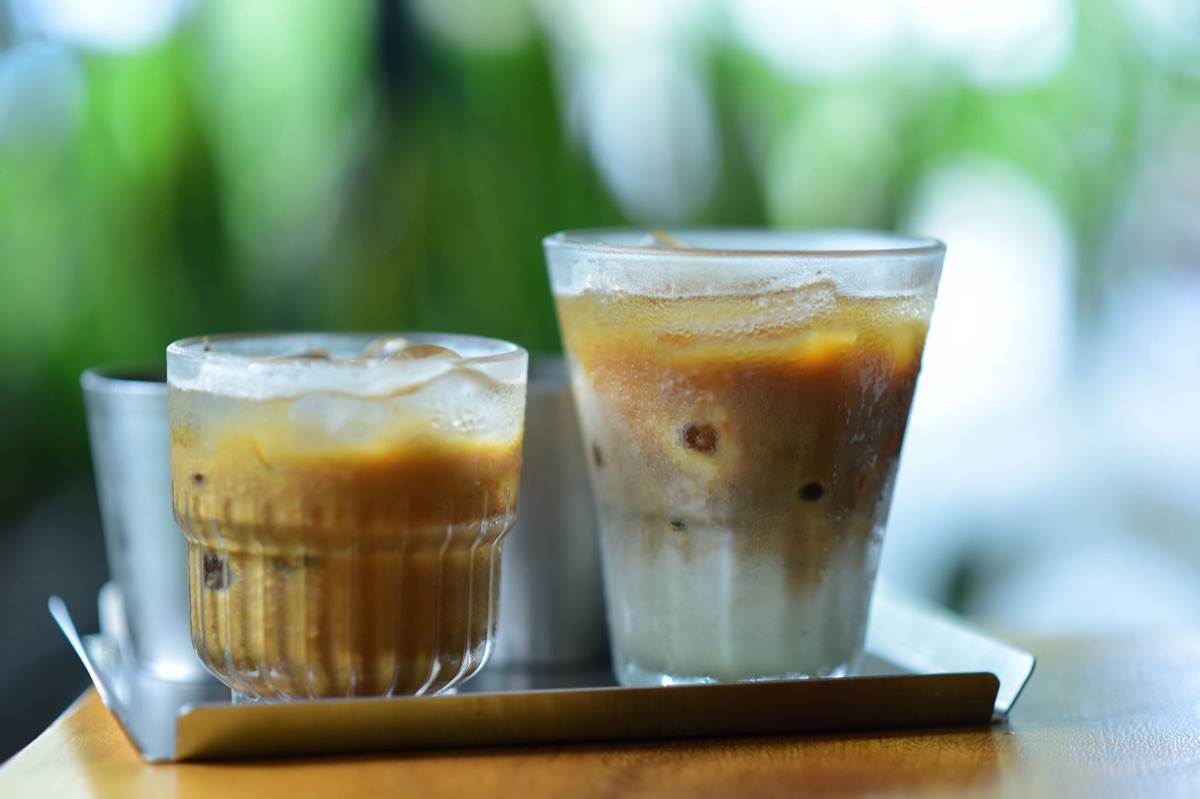 Eiskalter Kaffee mit Eiswürfeln und Milch in einem Glas