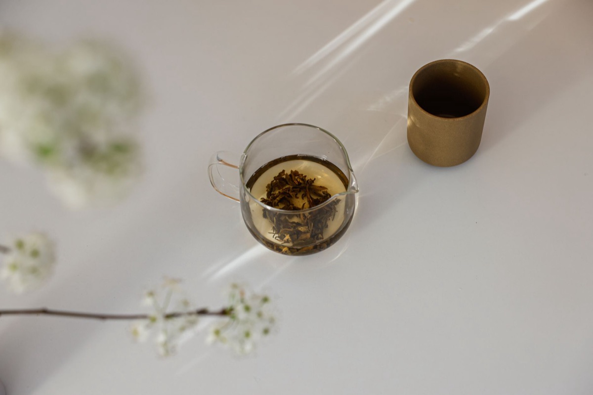 Organic green tea leaves in clear glass container