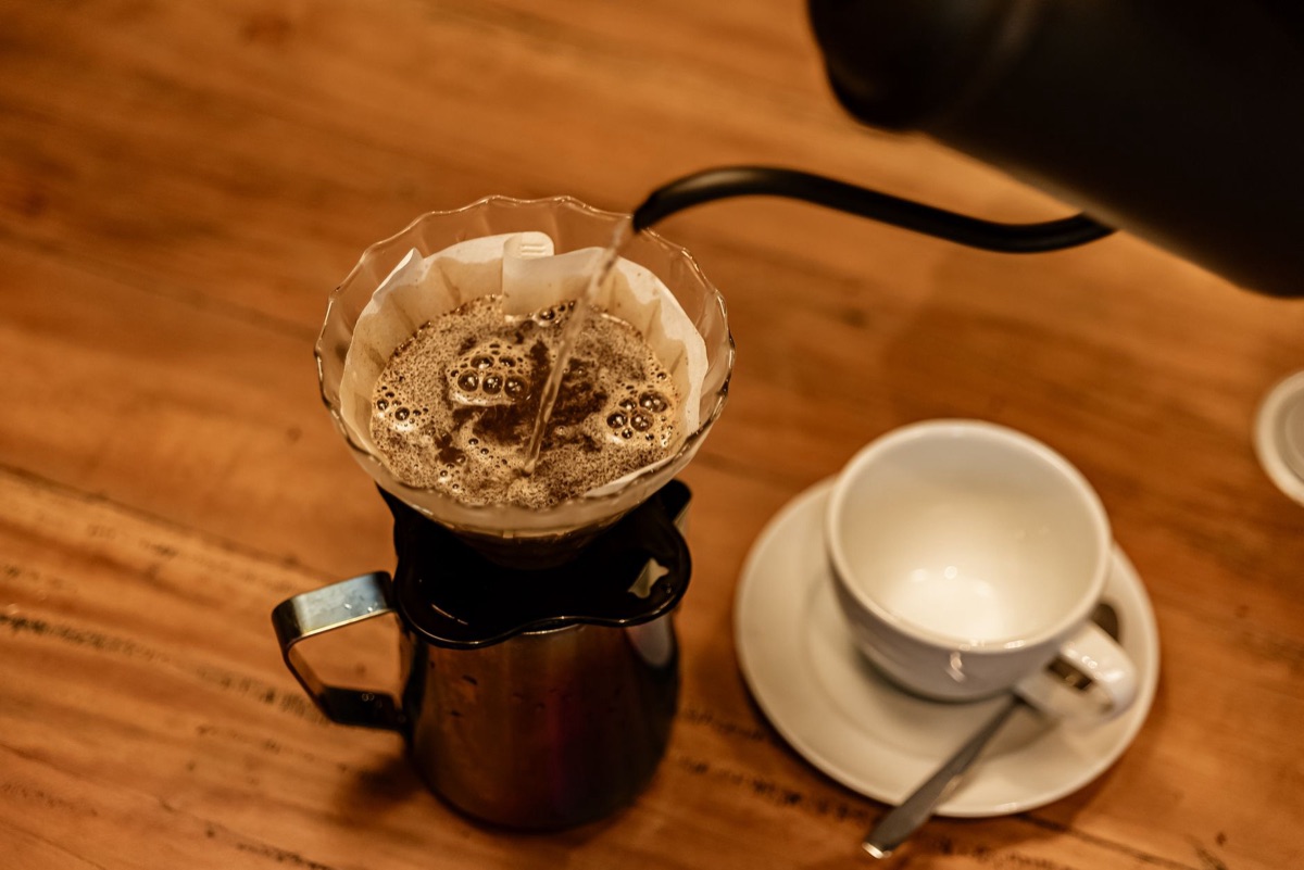 Versamento di acqua calda su caffè macinato per la preparazione del caffè a filtro.