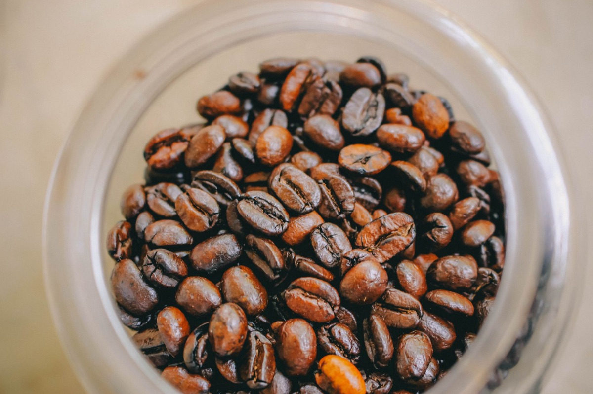 Opaque glass jar with dark roast coffee grounds